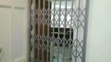 درب و حفاظ آکاردئونی نصبشده روی دیوار در کرمان