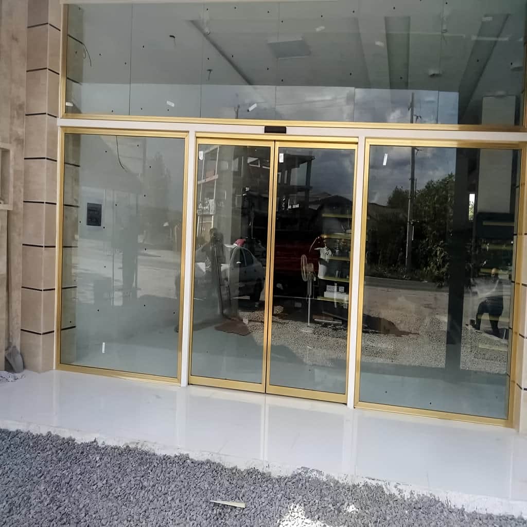 نصب درب اتوماتیک شیشه ای لولایی سنسوردار در ورودی کرمان