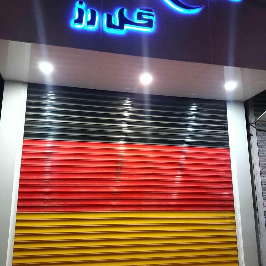 نصب کرکره برقی رنگی نمای فروشگاه در کرمان با ریل هماهنگ