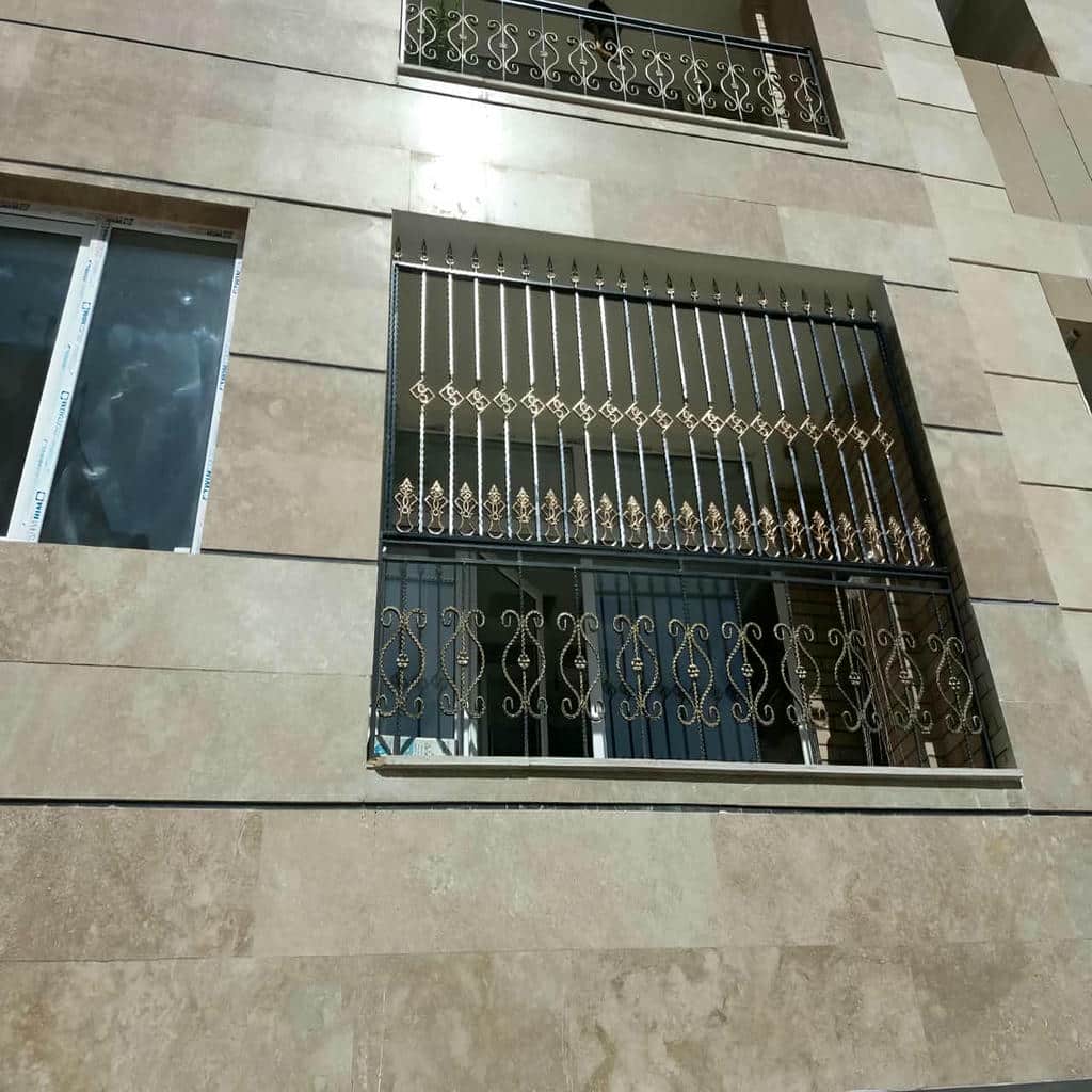 نمای نزدیک حفاظ پنجره گلنرده با گل فلزی